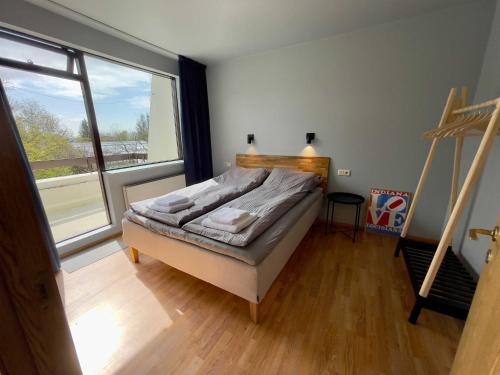 a bedroom with a bed and a large window at Matkráin Apartments in Hveragerði
