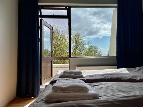 a bedroom with a bed and a large window at Matkráin Apartments in Hveragerði
