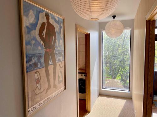 a hallway with a large painting on the wall and a window at Matkráin Apartments in Hveragerði
