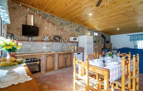 a kitchen with a table and chairs and a kitchen with at Casa rural Antonio y Esperanza in Periana