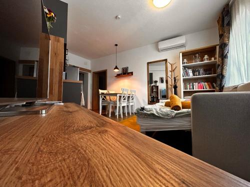 een woonkamer met een houten tafel en een eetkamer bij Puzzle Haus in Gyenesdiás