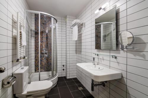 a bathroom with a sink and a toilet and a mirror at GINGER Hotel in Tbilisi City