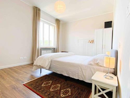 a white bedroom with a bed and a rug at CasaJila in Novi Ligure