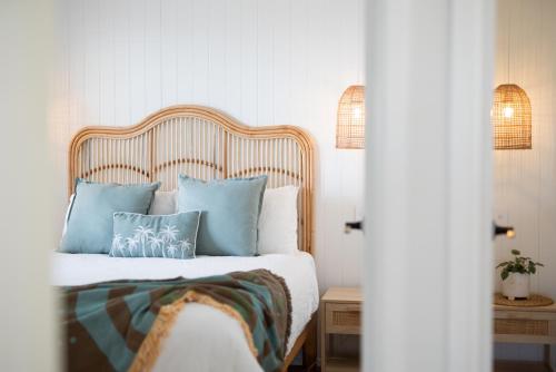 a bedroom with a bed with blue pillows at Sanbis Cabin - hidden boutique retreat, sea views in Aldinga Beach