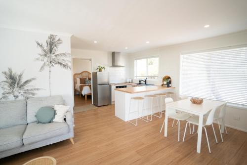 une cuisine et un salon avec un canapé et une table dans l'établissement Sanbis Cabin - hidden boutique retreat, sea views, à Aldinga Beach