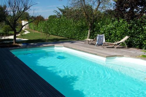 Beurlay的住宿－Maison Lépie，一个带两把椅子和一张桌子的大型蓝色游泳池