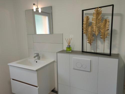 a white bathroom with a sink and a mirror at Célé Bulles Étoilées in Brengues