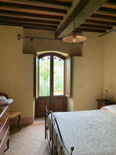 卡斯蒂廖內多爾恰的住宿－Podere le Mulina，一间卧室设有一张大床和一个大窗户