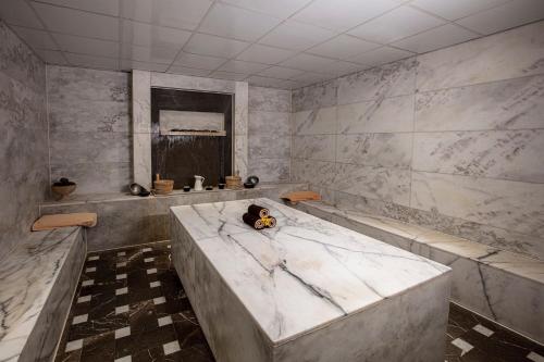 a bathroom with a large marble tub with a window at Iberotel Makadi Beach in Hurghada