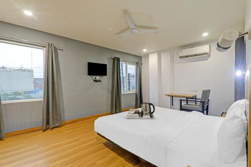 a hospital room with a white bed and a tv at Townhouse 386 The Shubham in Bijnaur