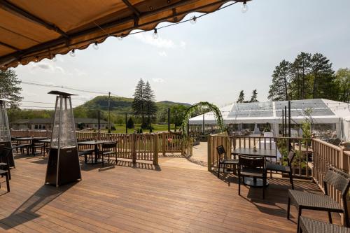 a deck with tables and chairs on a wooden deck at The Wentworth in Jackson