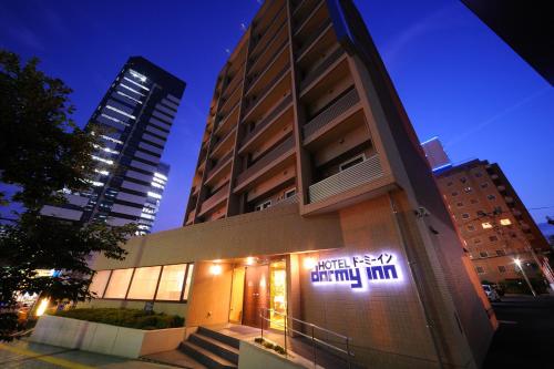 仙台Dormy Inn Sendai Station Natural Hot Springs的侧面有标志的建筑物