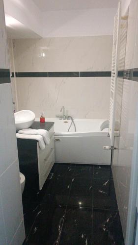 a bathroom with a white tub and a toilet at Central Apartments in Bucharest