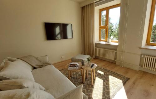 ein Wohnzimmer mit einem Sofa und einem Tisch in der Unterkunft LaSpa Beach House in Laulasmaa