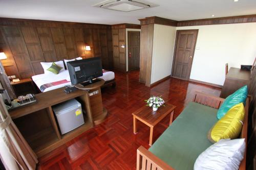 a living room with a couch and a tv in a room at Hua Hin Golf Villa in Hua Hin