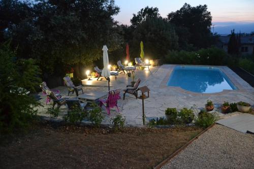 une terrasse avec une piscine, des chaises et une table dans l'établissement Appartement T2, à Montauroux