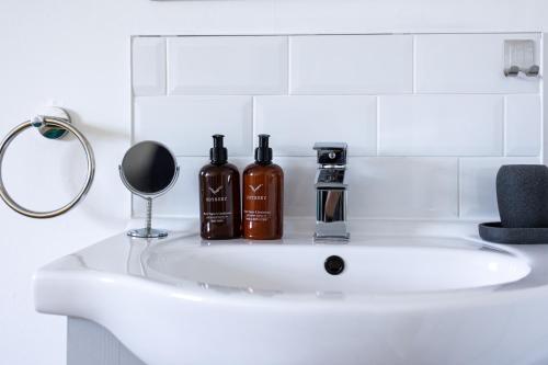 a bathroom sink with two bottles on it at The Wadham in Weymouth