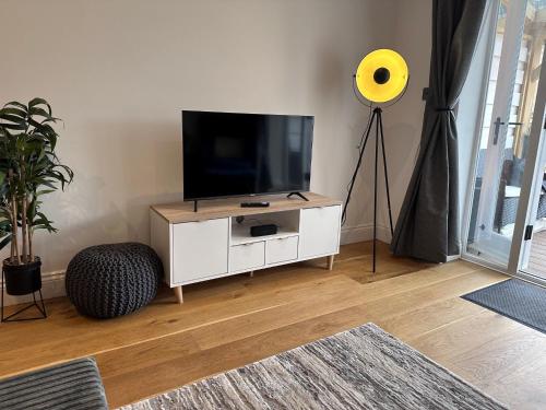 una sala de estar con TV en un armario blanco en House situated on River Itchen en Winchester