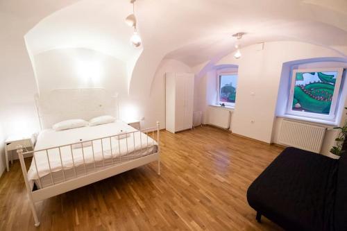 ein Schlafzimmer mit einem weißen Bett in einem Zimmer in der Unterkunft Dragon's Cave in Ljubljana