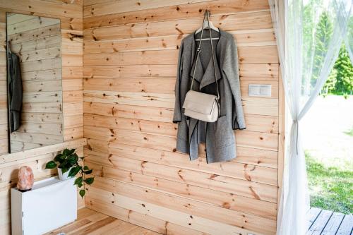 pared de madera en una habitación con abrigo y bolso en Rouna Family Home en Ainja