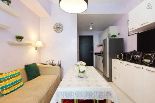 ein Wohnzimmer mit einem Sofa und einer Küche in der Unterkunft Condo Studio Luxe in Princeton Residences in Manila