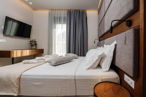 a hotel room with a large bed with white pillows at Horizon Apartments - Beachfront Luxury, by ZanteWize in Laganas