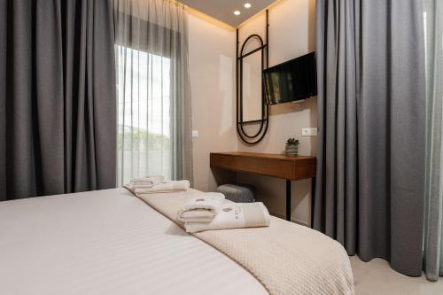 a bedroom with a bed and a desk and a window at Horizon Apartments - Beachfront Luxury, by ZanteWize in Laganas