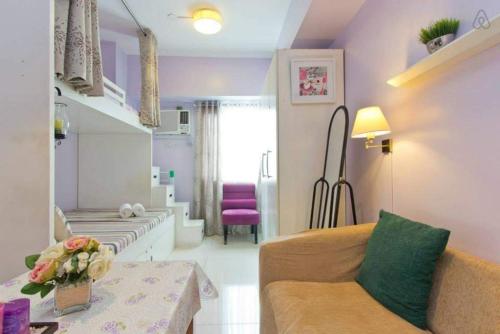 ein kleines Wohnzimmer mit einem Sofa und einem Wohnzimmer in der Unterkunft Condo Studio Luxe in Princeton Residences in Manila