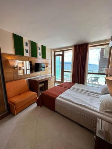 a bedroom with a bed and a desk and window at Briz Beach apartments - section B in Sunny Beach