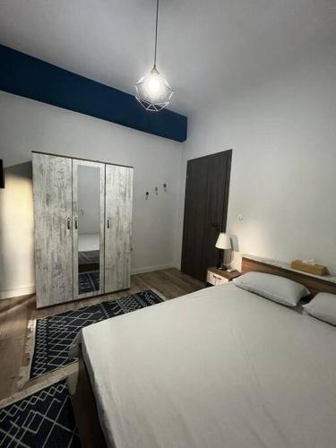 una camera da letto con un grande letto bianco e uno specchio di Beautiful Apartment in Corfu a Ágios Rókkos