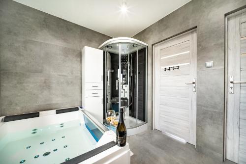 een grote badkamer met een bad en een douche bij Domek hot tub jacuzzi Chillout in Kołobrzeg