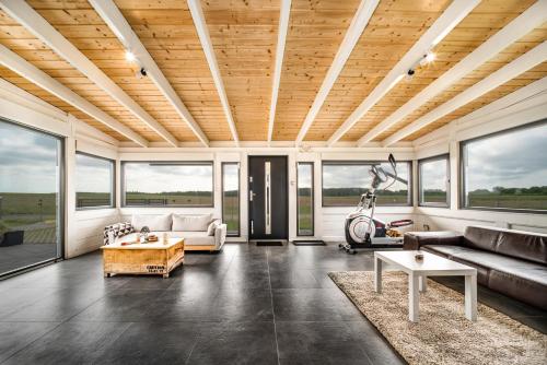 un soggiorno con soffitto in legno e ampie finestre di Domek hot tub jacuzzi Chillout a Kołobrzeg