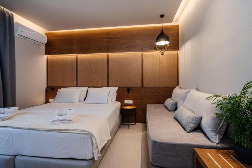 a bedroom with two beds and a couch at Horizon Apartments - Beachfront Luxury, by ZanteWize in Laganas