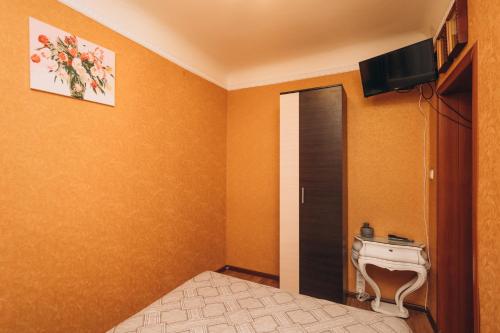 a bedroom with a bed and a tv and a door at Квартира в центре города in Sumy
