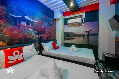 2 Betten in einem Zimmer mit Wandgemälde in der Unterkunft Sabel Travelers Inn in Laoag