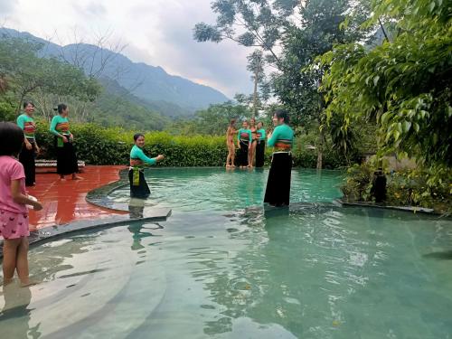 a group of people standing in a pool of water at Puluong homestay1holiday in Pu Luong