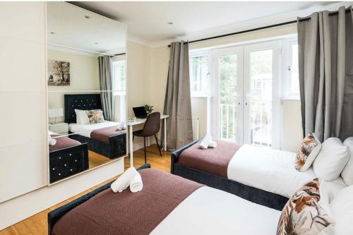 ロンドンにあるWhere Style & Convenience Combine- Photo ID & Deposit Requiredのベッド2台と鏡が備わるホテルルームです。
