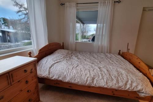 sypialnia z łóżkiem z komodą i oknem w obiekcie Quiet and comfy with swimming pool w mieście Onsala