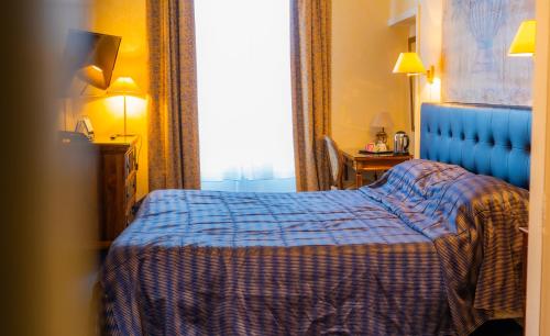 um quarto de hotel com uma cama e uma janela em Churchill Hotel Bayeux Centre em Bayeux