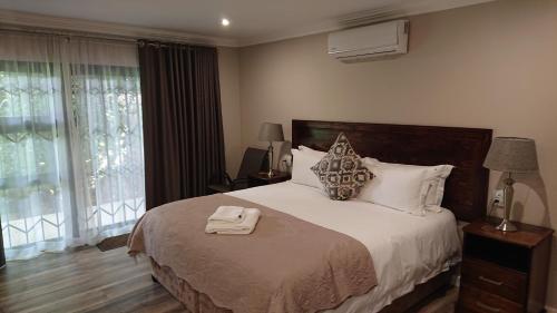 a bedroom with a large bed and a window at Unitas Guesthouse in Centurion