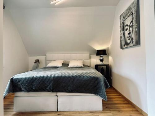 ein Schlafzimmer mit einem Bett in einem weißen Zimmer in der Unterkunft Moderne Ferienwohnung Zweifall in Stolberg