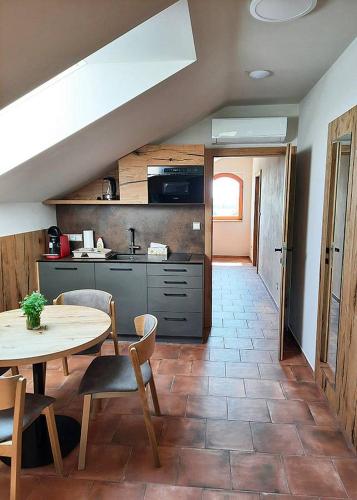 a kitchen with a table and a table and chairs at Sklep Víno Strýček in Velké Bílovice