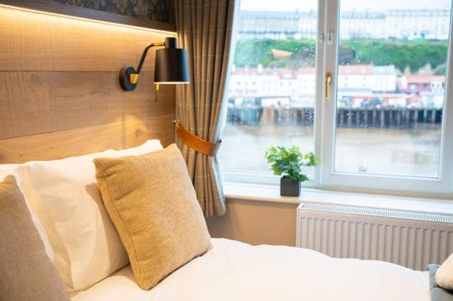 a bedroom with a white bed with a window at Duke of York in Whitby