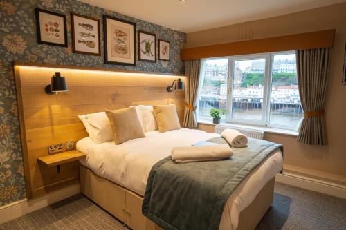 una camera d'albergo con letto e finestra di Duke of York a Whitby