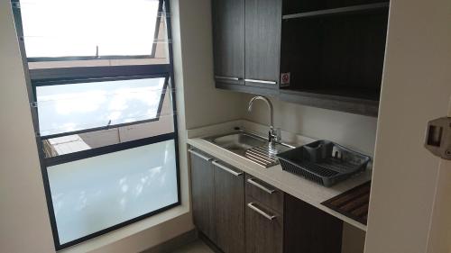 eine kleine Küche mit einem Waschbecken und einem Fenster in der Unterkunft Unitas Guesthouse in Centurion