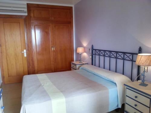 サン・ホセにあるApartamento en la Playa de San José-sjjcのベッドルーム1室(ベッド1台付)、2泊分のスタンド(ランプ付)