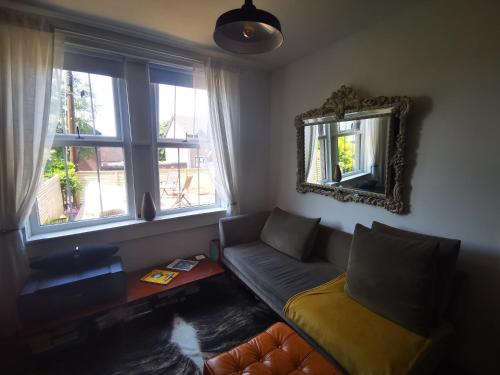 uma sala de estar com um sofá e um espelho em Newly Renovated 3 bedroom house em Taibach