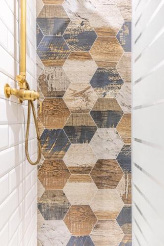 une salle de bain avec un plancher en bois et une porte de douche dans l'établissement La bécanerie Calme et Duplex, à Pont-du-Château