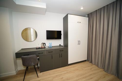 a bathroom with a vanity with a mirror and a chair at B&M Hotel in Yerevan