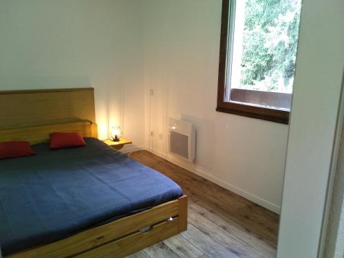 - une chambre avec un lit bleu et une fenêtre dans l'établissement Appartement 39 M² 2/4 personnes avec piscine, à Aspin-en-Lavedan